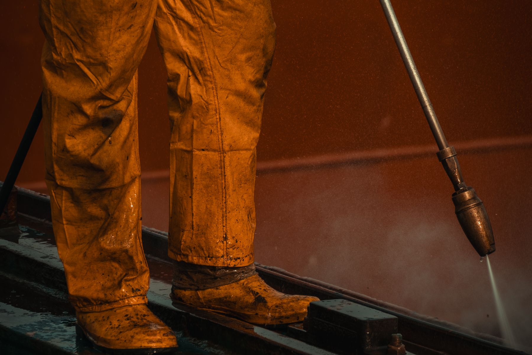 Worker using commercial pressure washing equipment